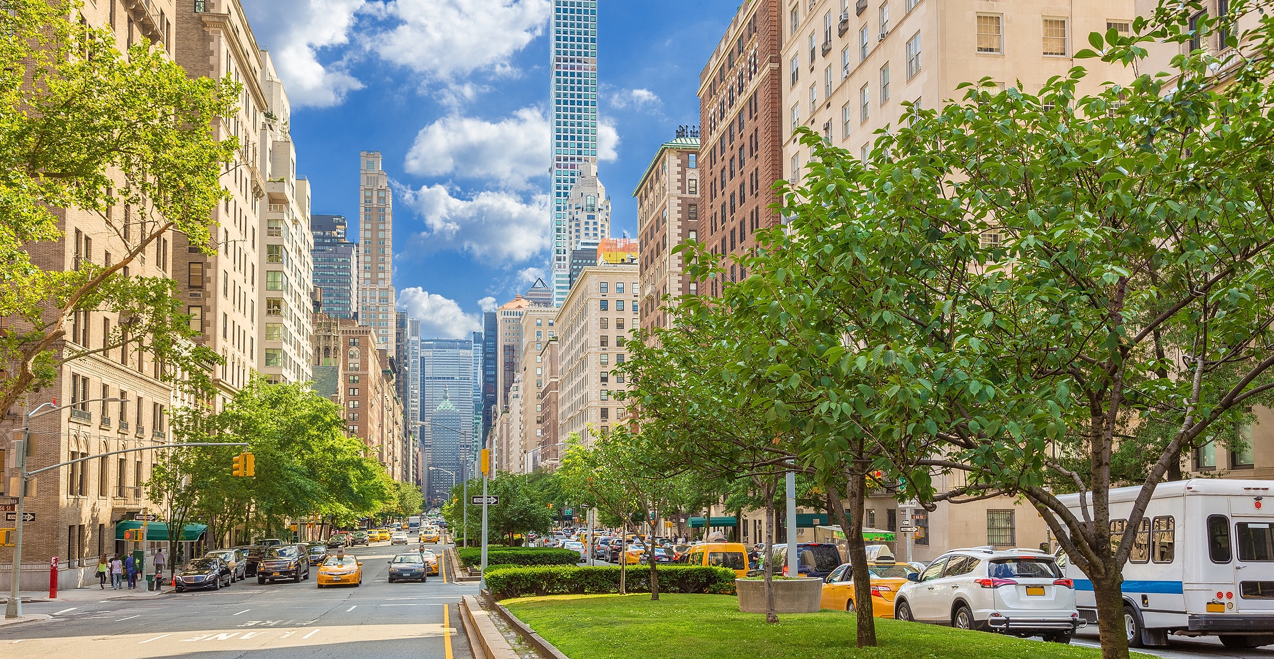New York City street view with skyscrapers and trees.