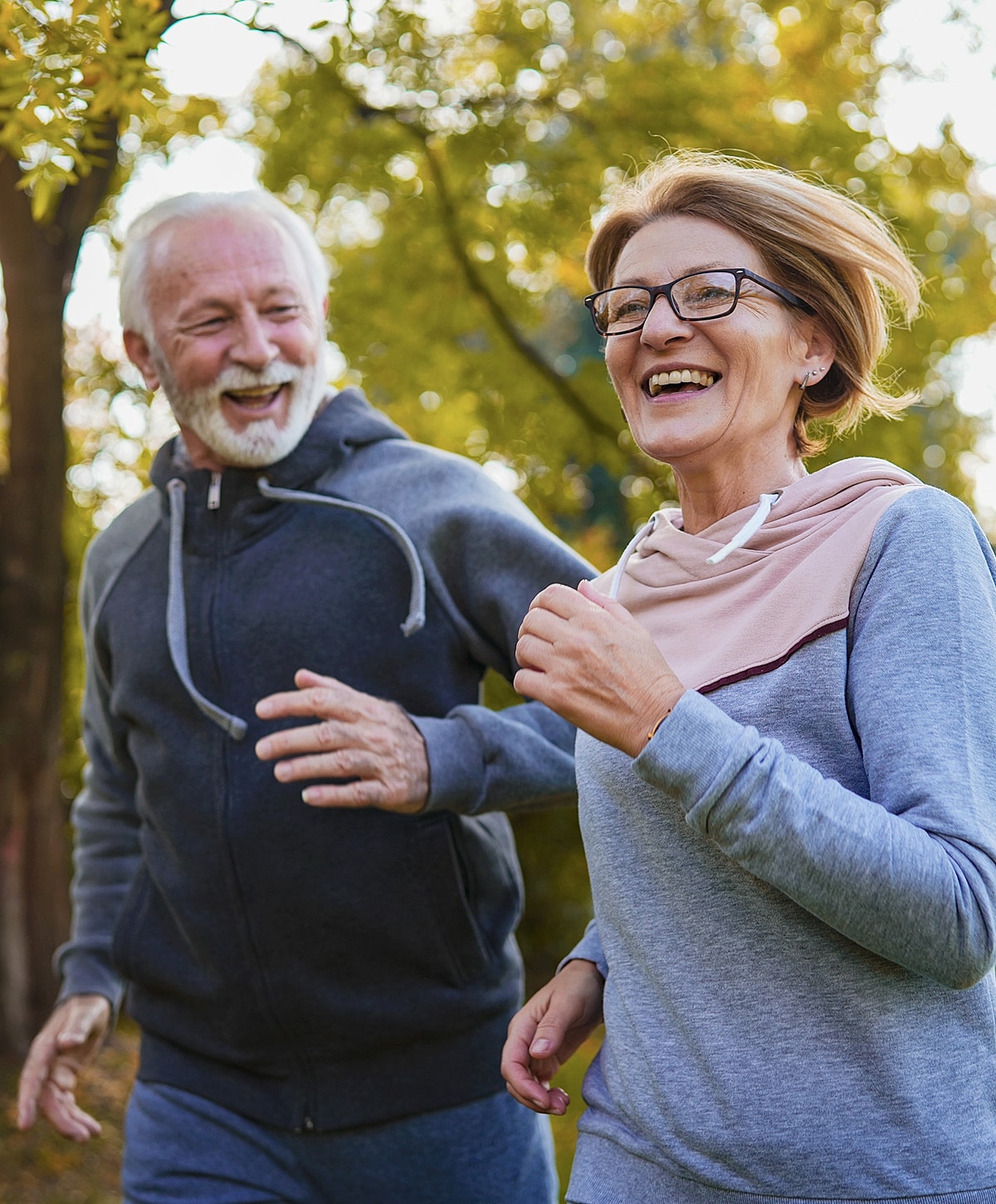 Happy seniors jogging in a park.
