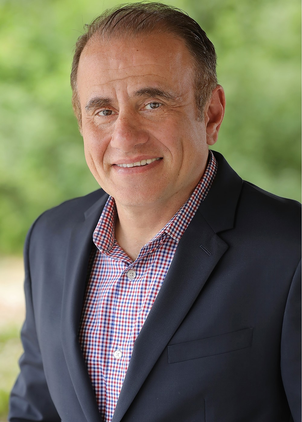 Smiling man in business attire portrait outdoors.