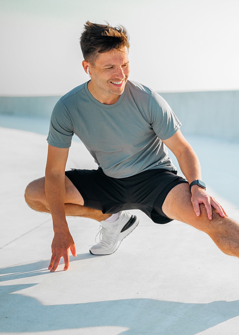Man exercising outdoors with wireless earbuds.