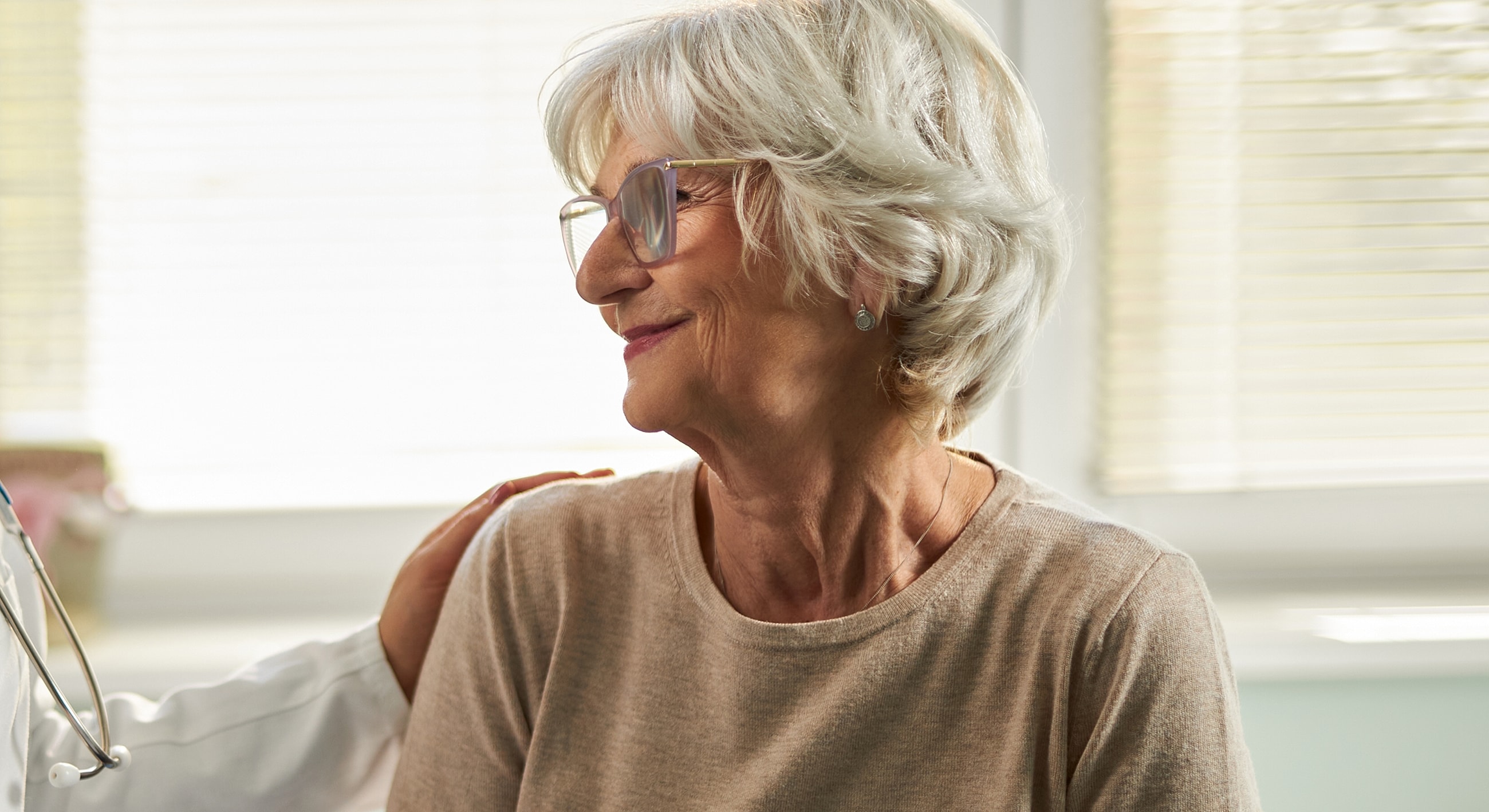 Senior woman smiling during doctor visit.