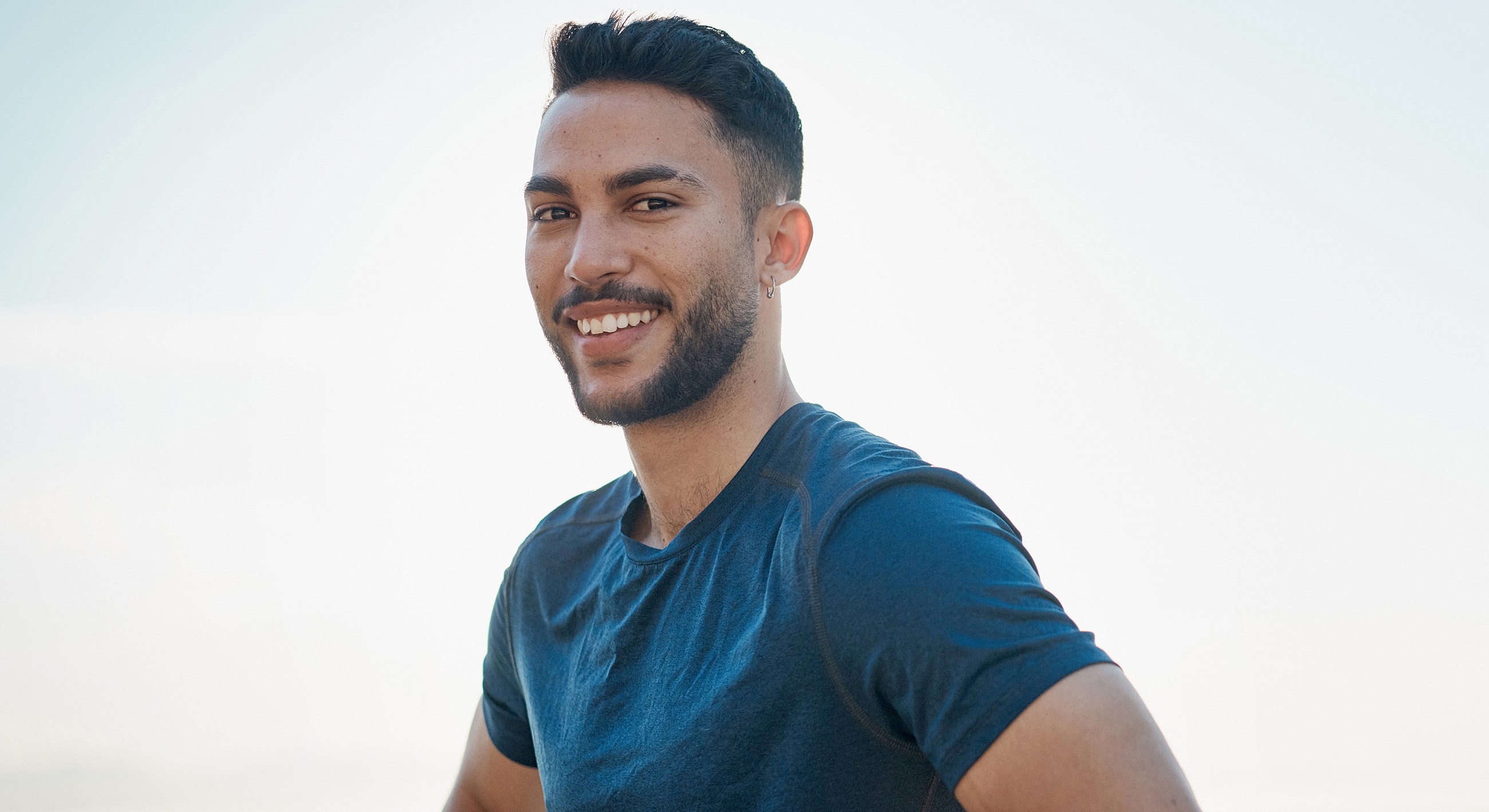 Smiling man in a blue shirt outdoors.