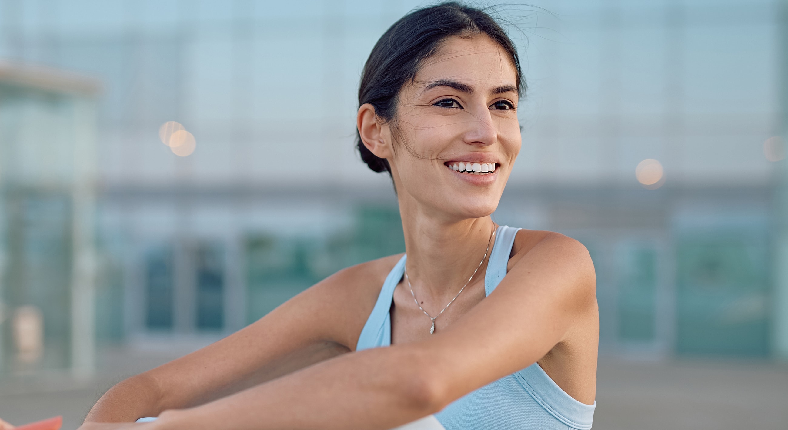 Smiling woman in athletic wear outdoors.